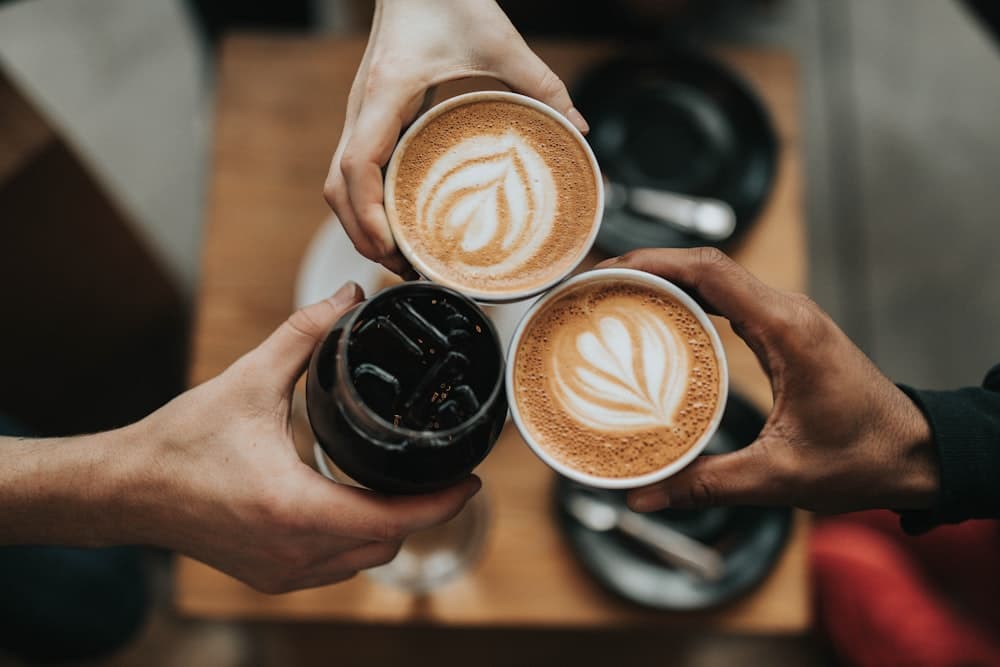 Friends raising their coffee cups together