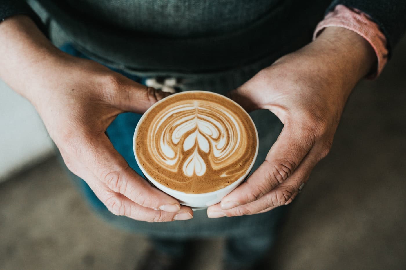 A barista presenting a fresh latte
