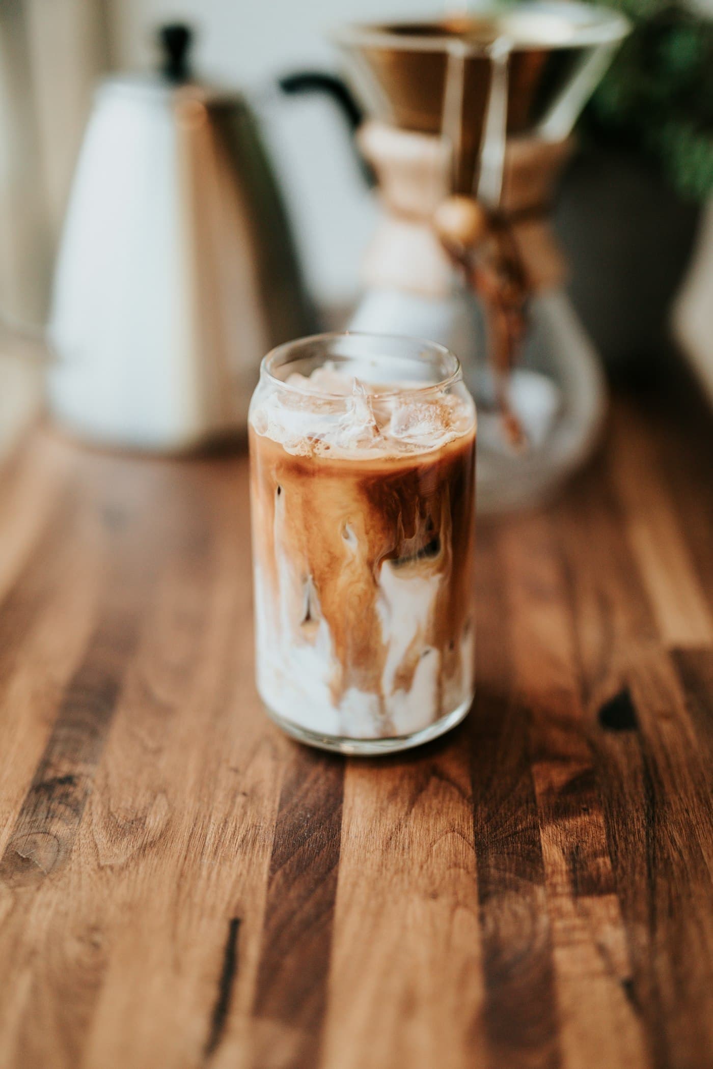 An iced coffee with cream in a tall glass