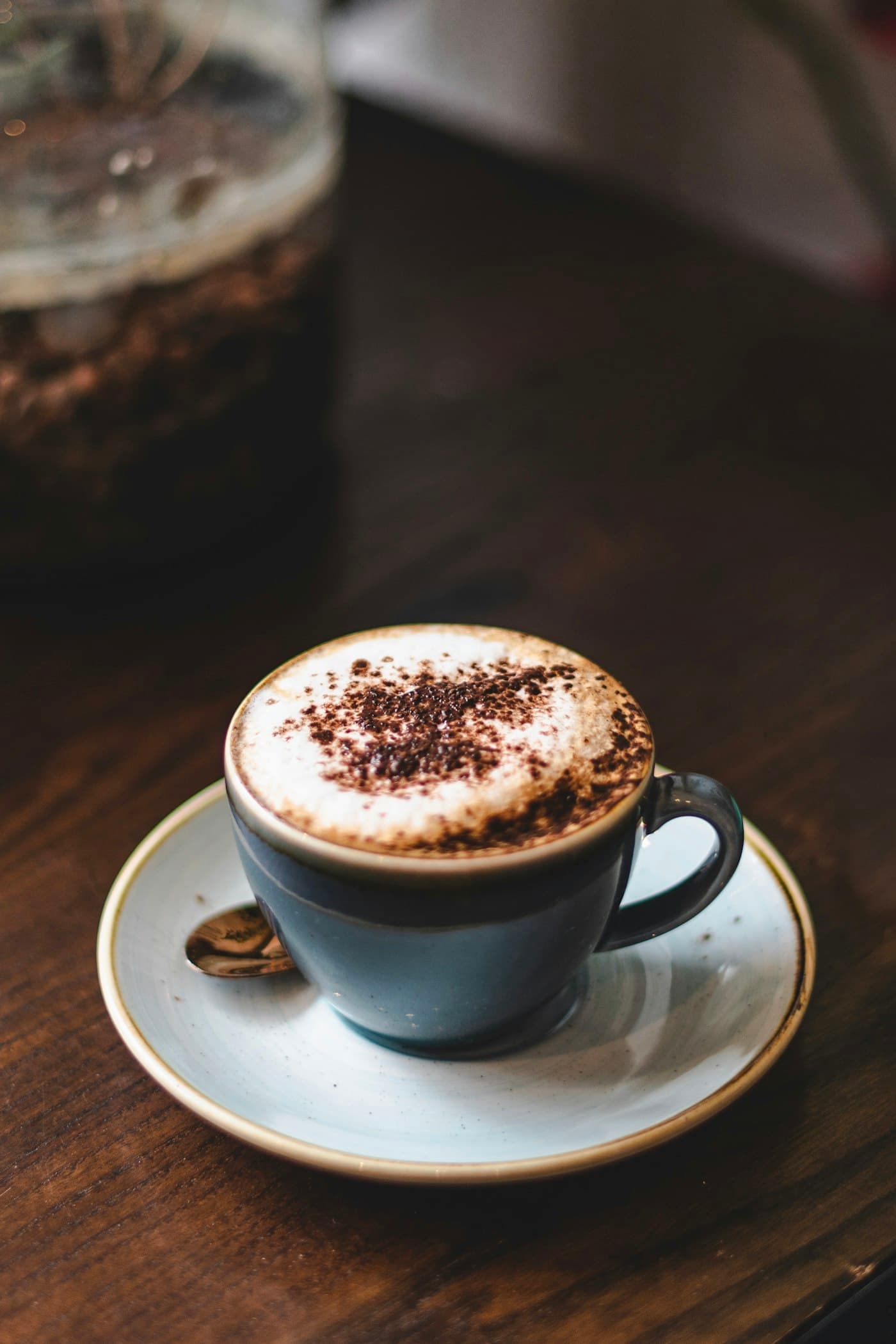 A mocha dusted with spice in a dark cup